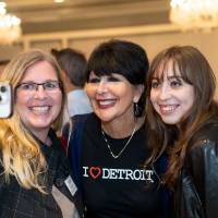 Photo of two event guests taking a selfie with President Mantella